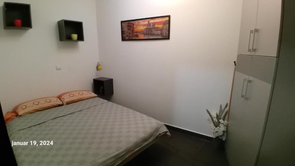 a bedroom with a bed and a picture on the wall at Sunshine II Apartment in Kragujevac