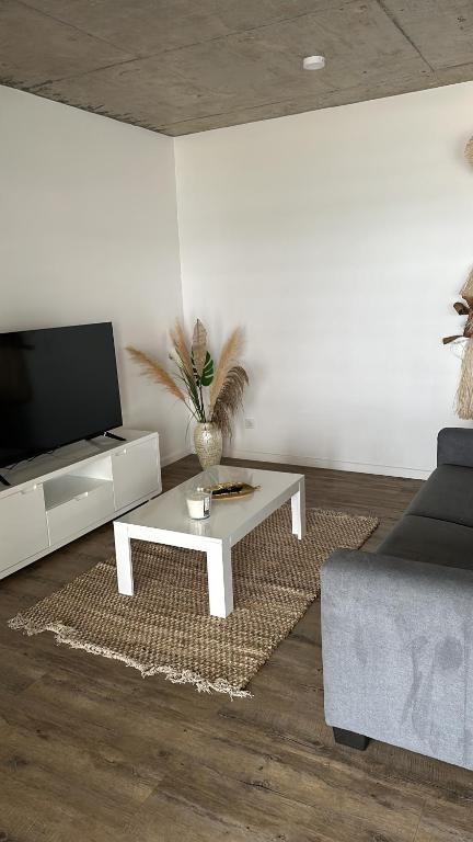 a living room with a coffee table and a tv at Pension Irivai appartement "Uparu" 1 chambre bord de mer in Uturoa