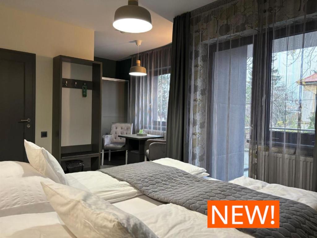 ニーレジハーザにあるIkonik Spa Hotelのベッド2台とダイニングエリアが備わるホテルルームです。