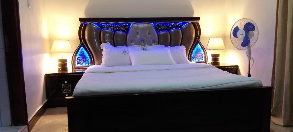 una camera con un grande letto con testiera blu di Dream Palace Hotel Mbale a Mbale