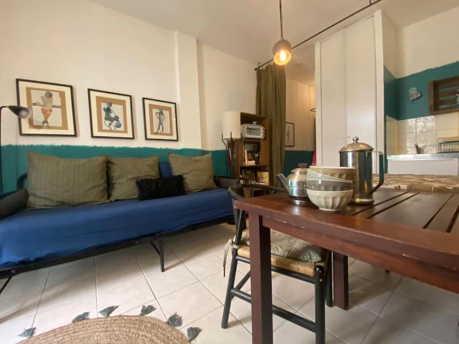 a living room with a blue couch and a table at Invitation au voyage sur cour in Sète