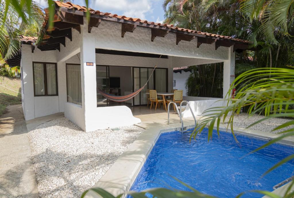a house with a hammock and a swimming pool at Villa Serenidad Costera in Sardinal