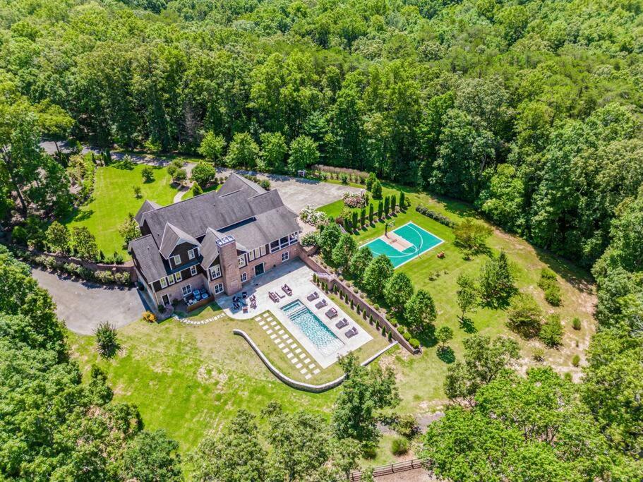 an aerial view of a large house with a swimming pool at Luxury Mountain Mansion, 7BR, 8 king beds, 10000sf, Views, Pool, Sport Court, Gym, Sauna, Petting Zoo in Blue Ridge