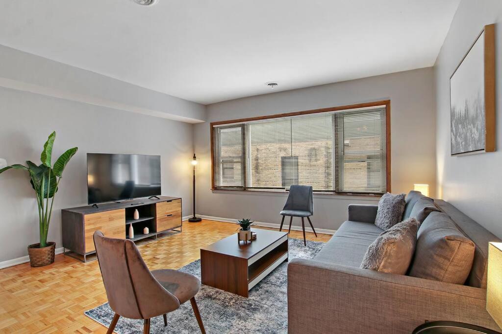 a living room with a couch and a flat screen tv at Prime 2-Bedroom Oasis - Church 304 in Evanston