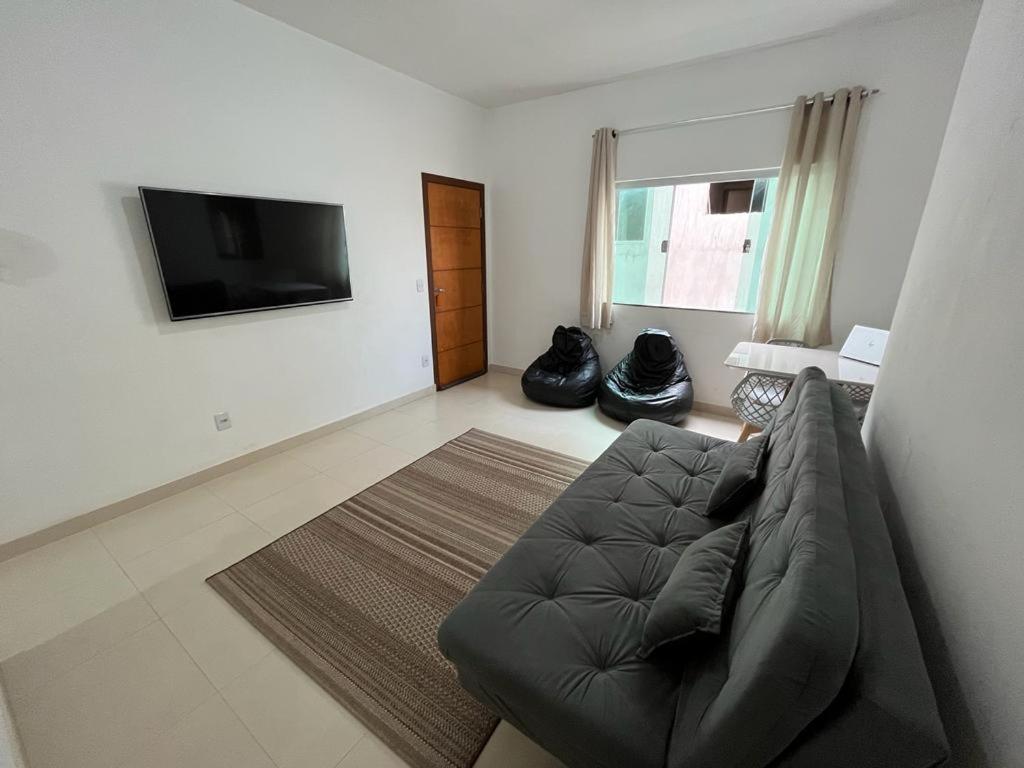 a living room with a couch and a flat screen tv at Apartamento Aconchegante in Capitólio