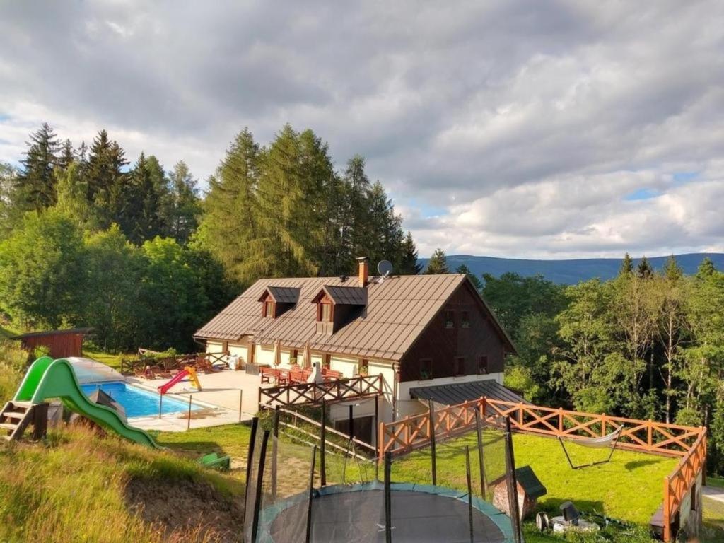 an image of a house with a playground at Ferienhaus am Waldrand mit Schwimmbad und Sauna in Strážné