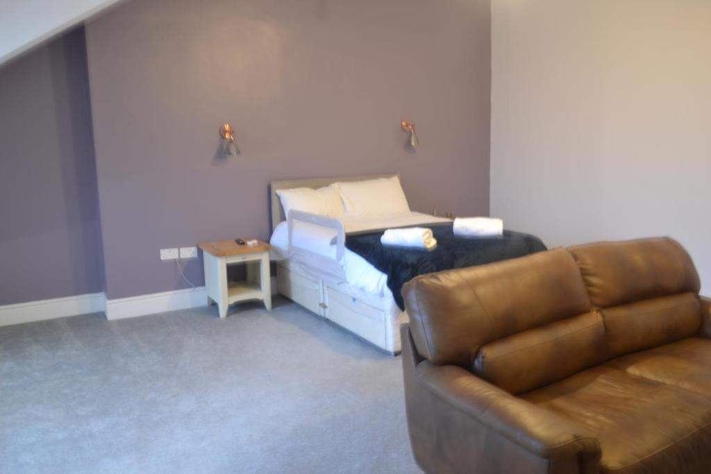 a living room with a couch and a bed at Ashbrooke Homestay in Sunderland