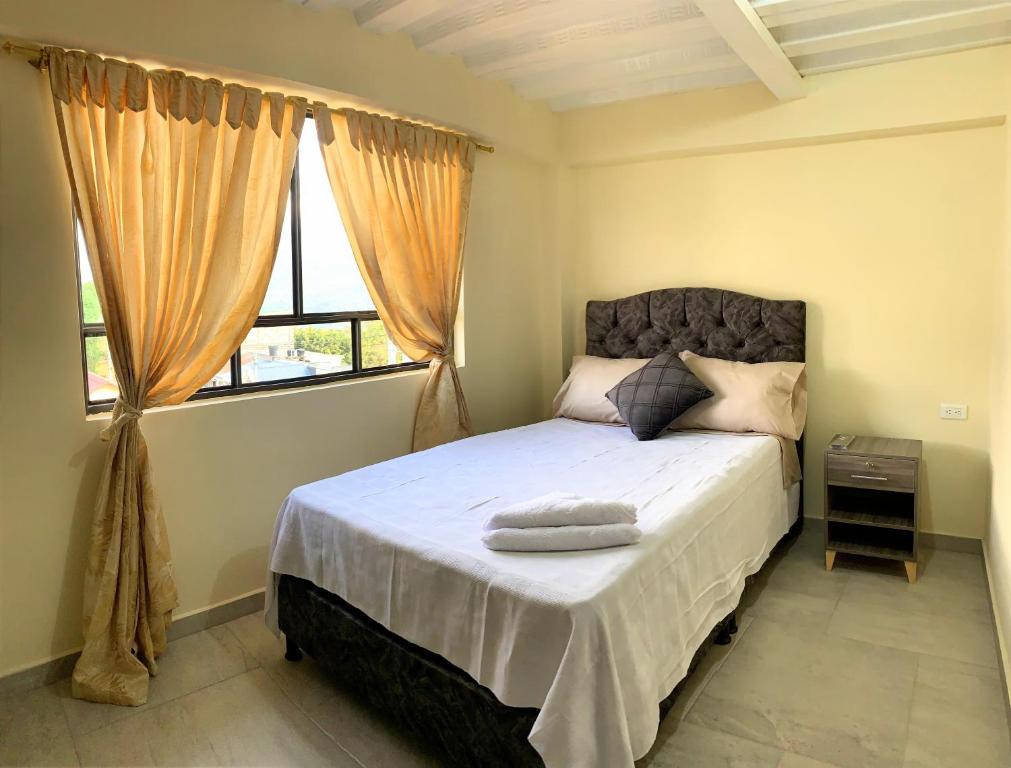 um quarto com uma cama grande e uma janela em Posada RoRi em Choachí