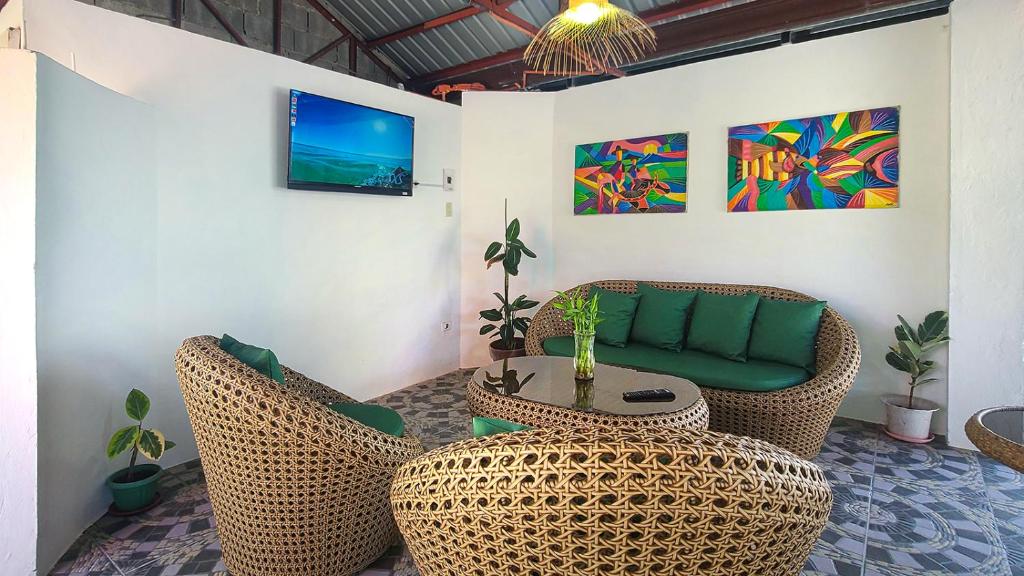 a living room with wicker chairs and a green couch at EspIliNorte, Stay and Play in San Juan