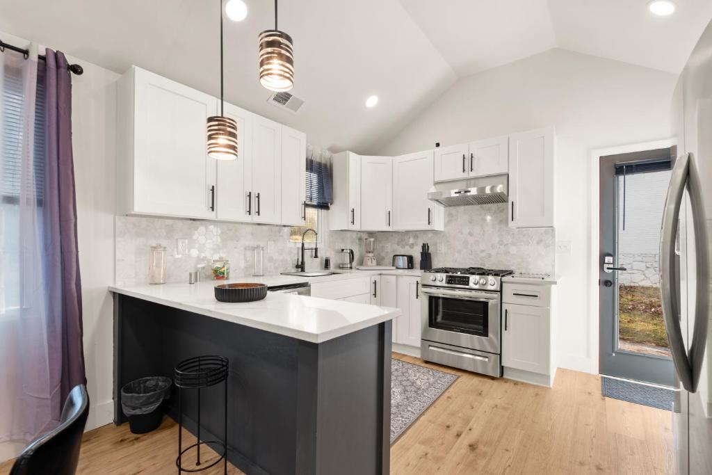 a kitchen with white cabinets and a stove top oven at New Decatur Bungalow in Decatur