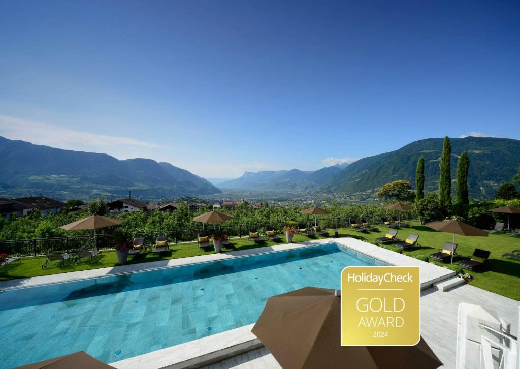 un complexe avec une piscine et un panneau indiquant le prix de l'or dans l'établissement Hotel Patrizia, à Tirolo