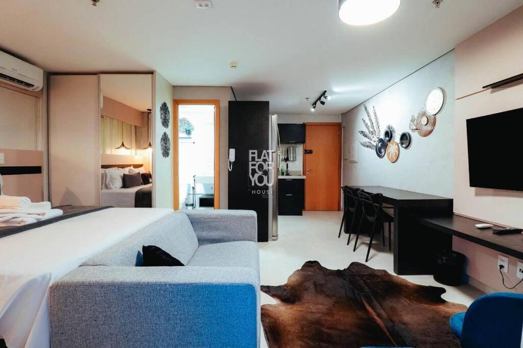 uma ampla sala de estar com um sofá e uma cozinha em #2216# APÊ LINDO E ACONCHEGANTE COM CHURRASQUEIRA em Goiânia