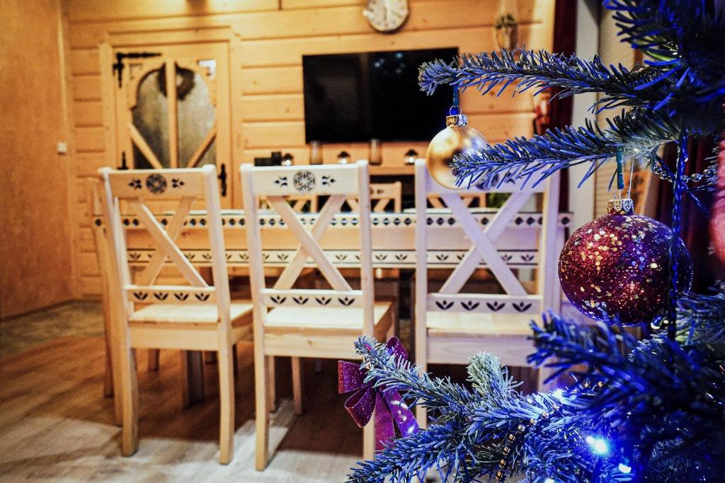 a dining room with a christmas tree and a table and chairs at Domek na Zakręcie in Zakopane