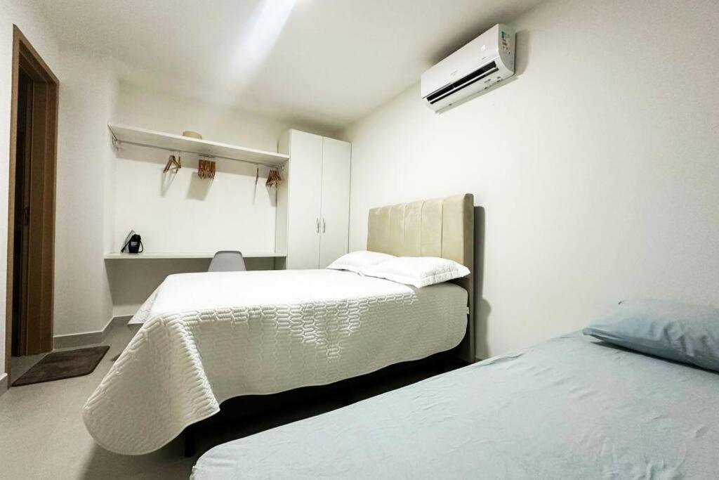 um quarto com duas camas e uma televisão na parede em Apartamento Alto Padrão Jatiúca - Maceió - Alagoas em Maceió