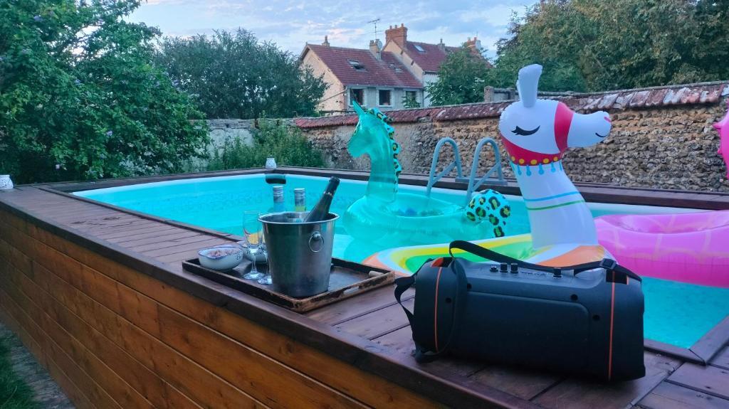 a suitcase sitting next to a swimming pool at Chez Aurélia - Chambres &amp; Table d&#39;hôtes in La Couture-Boussey