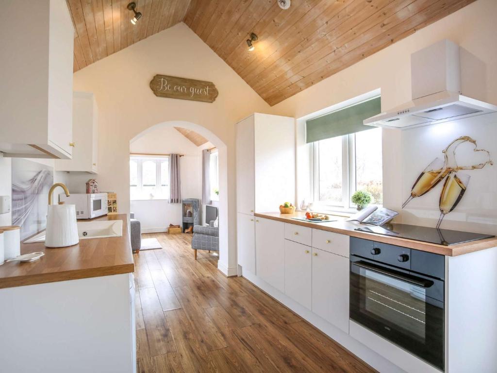 a kitchen with white cabinets and a stove top oven at 1 Bed in Nr. Rothbury 82147 in Longhorsley