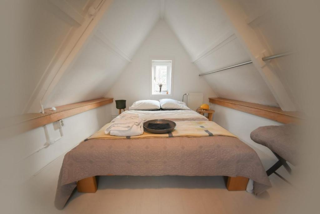 een slaapkamer met een groot bed op zolder bij Zomerhuisje Wijk aan Zee in Wijk aan Zee