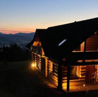 a house with a light on the side of it at Villa Beskid in Milówka