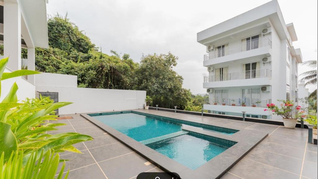 uma imagem de uma piscina em frente a um edifício em Premium 2BHK Apartment with pool at Candolim Beach em Candolim