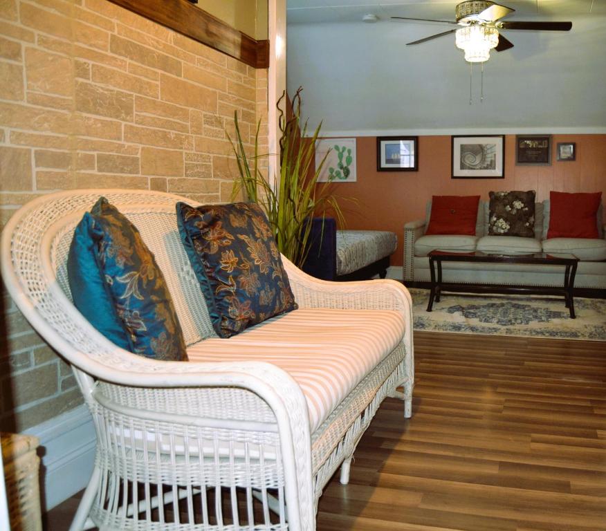 a wicker chair with pillows on it in a living room at City Pads in Grand Forks