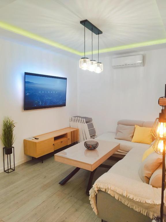 a living room with a couch and a tv on a wall at City Castle, Granada center, casa completa in Granada