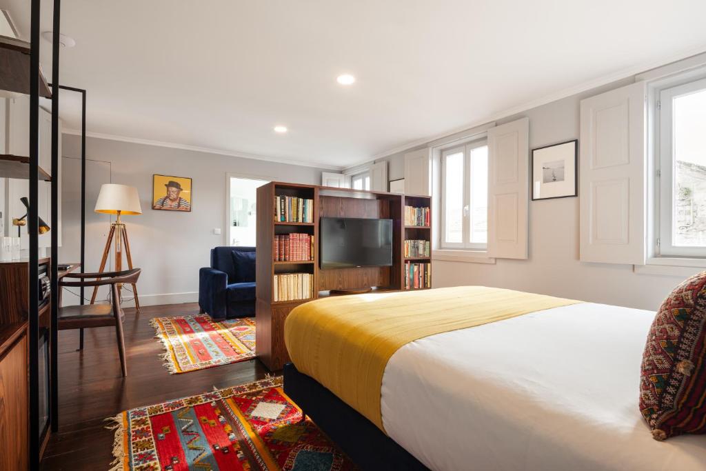 a bedroom with a bed and a tv in a room at Utopian Hotel, a charming guesthouse in Porto