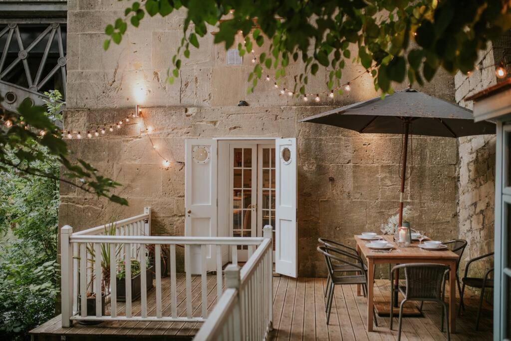 a table with an umbrella on a patio at Historic House On The Bridge in Bath