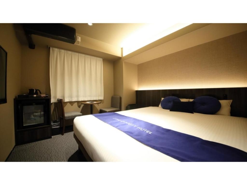 a hotel room with a large bed and a window at Dynasty Hotel Osaka - Vacation STAY 61762v in Osaka