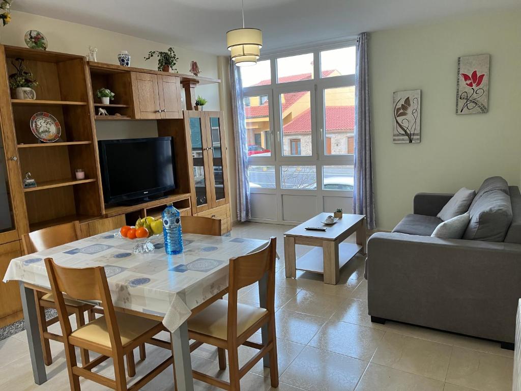 uma sala de estar com uma mesa e um sofá em Apartamento Finisterrae em Fisterra