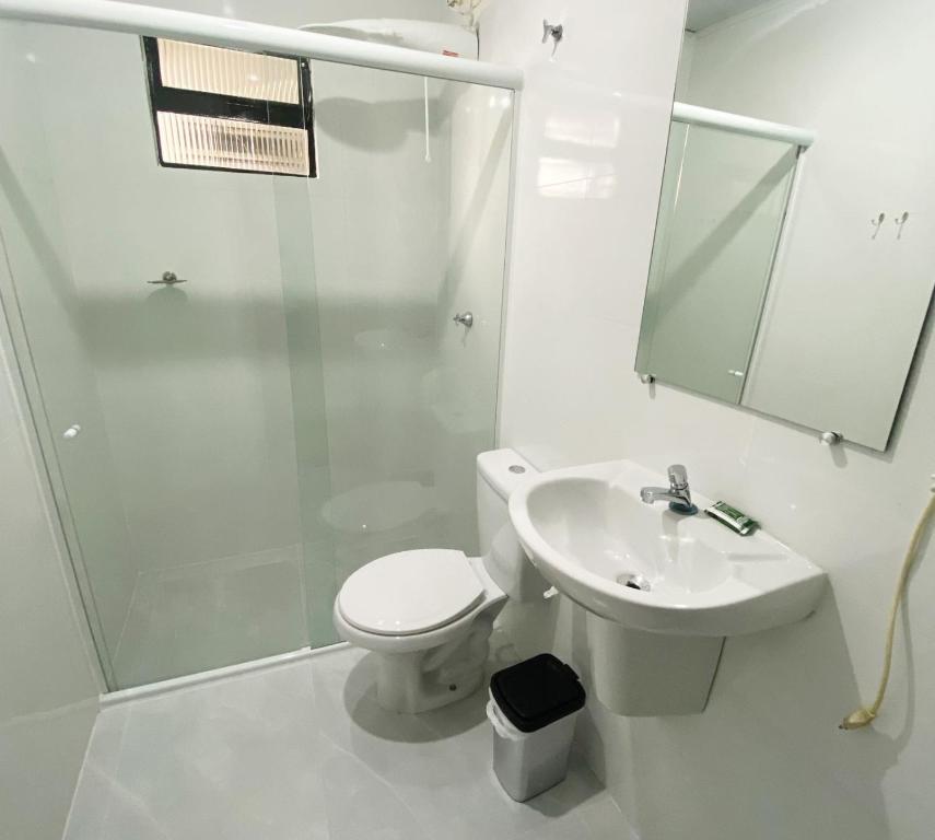 a bathroom with a toilet and a sink and a shower at Itaipu Hotel in Foz do Iguaçu