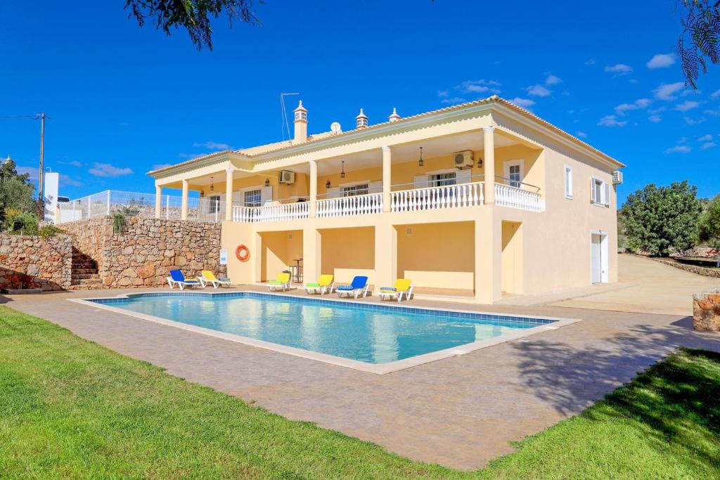 een villa met een zwembad voor een huis bij Villa Entrecolinas in São Bartolomeu de Messines