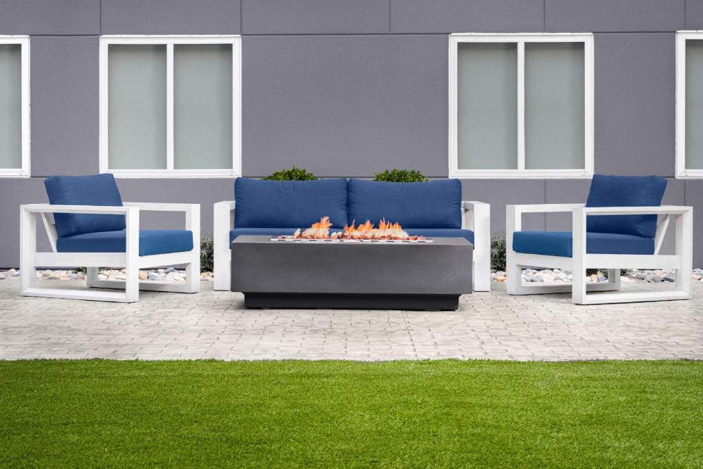 two blue and white chairs and a fire pit at stayAPT Suites Killeen-Fort Cavazos in Killeen