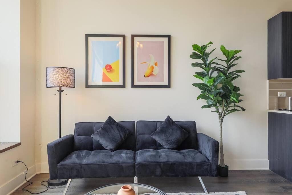 a blue couch in a living room with three pictures on the wall at McCormick 2Br/2Ba family unit for up to 6 guests with Optional Parking & Gym in Chicago