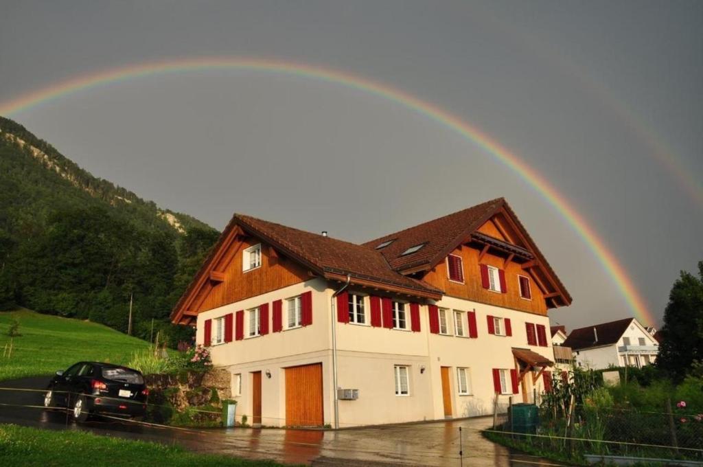 Arth的住宿－Ferienwohnung Sagenmattli，彩虹在房子上方
