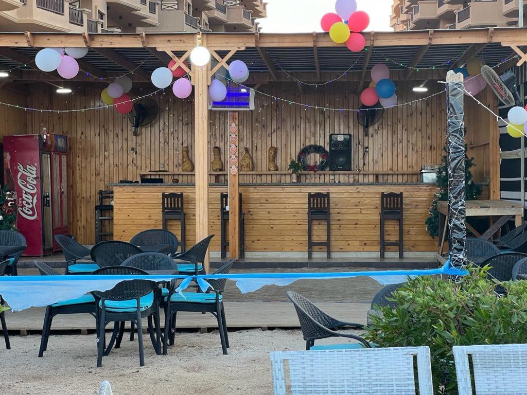 un patio con mesa, sillas y piscina en Lovely bedroom apartment TBR, en Hurghada