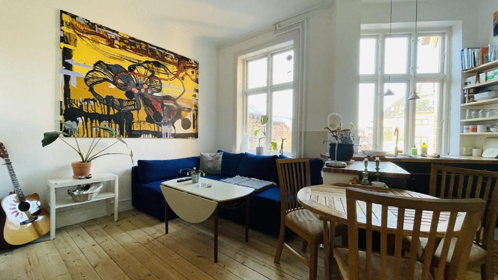 un soggiorno con divano blu e tavolo di ApartmentInCopenhagen Apartment 1586 a Copenaghen