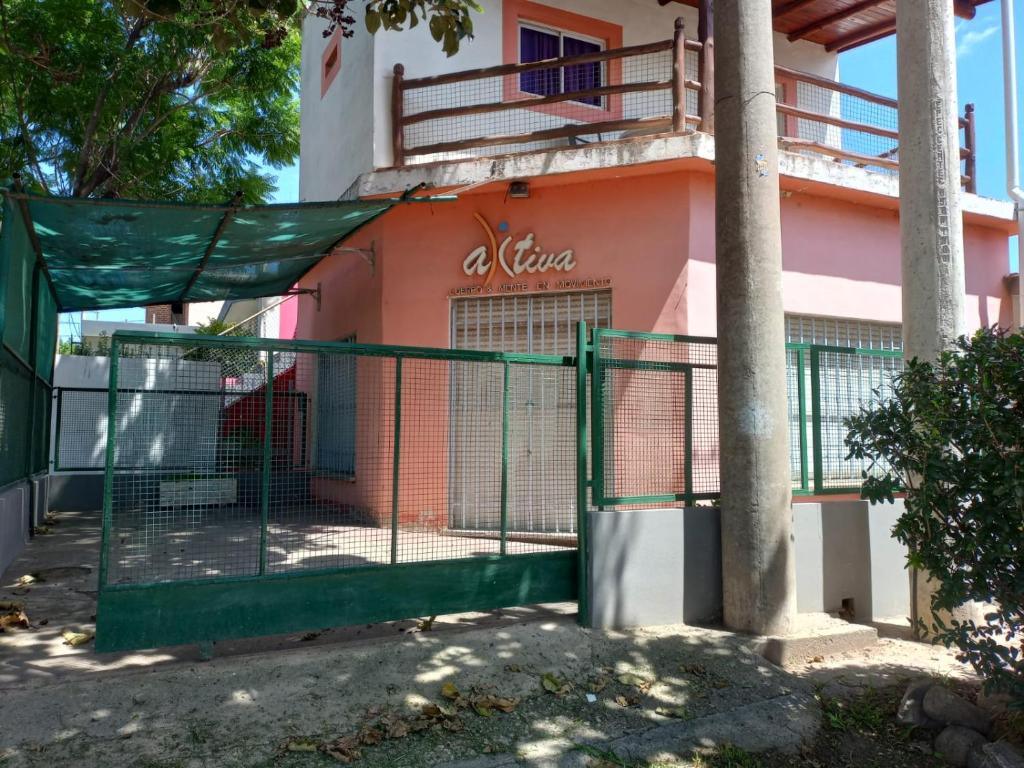 a gate in front of a pink building at Salón Amplio Céntrico Habitación Privada 4 personas in Cosquín