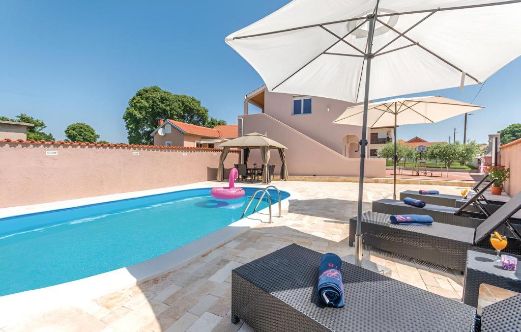 een villa met een zwembad en een parasol bij Elegant Villa Jure with private pool in Poličnik