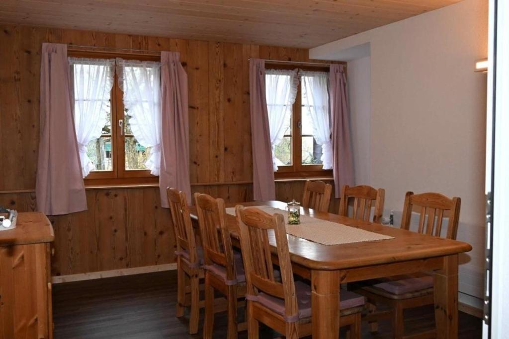 Bauernhof Sal في Bütschwil: غرفة طعام مع طاولة وكراسي خشبية