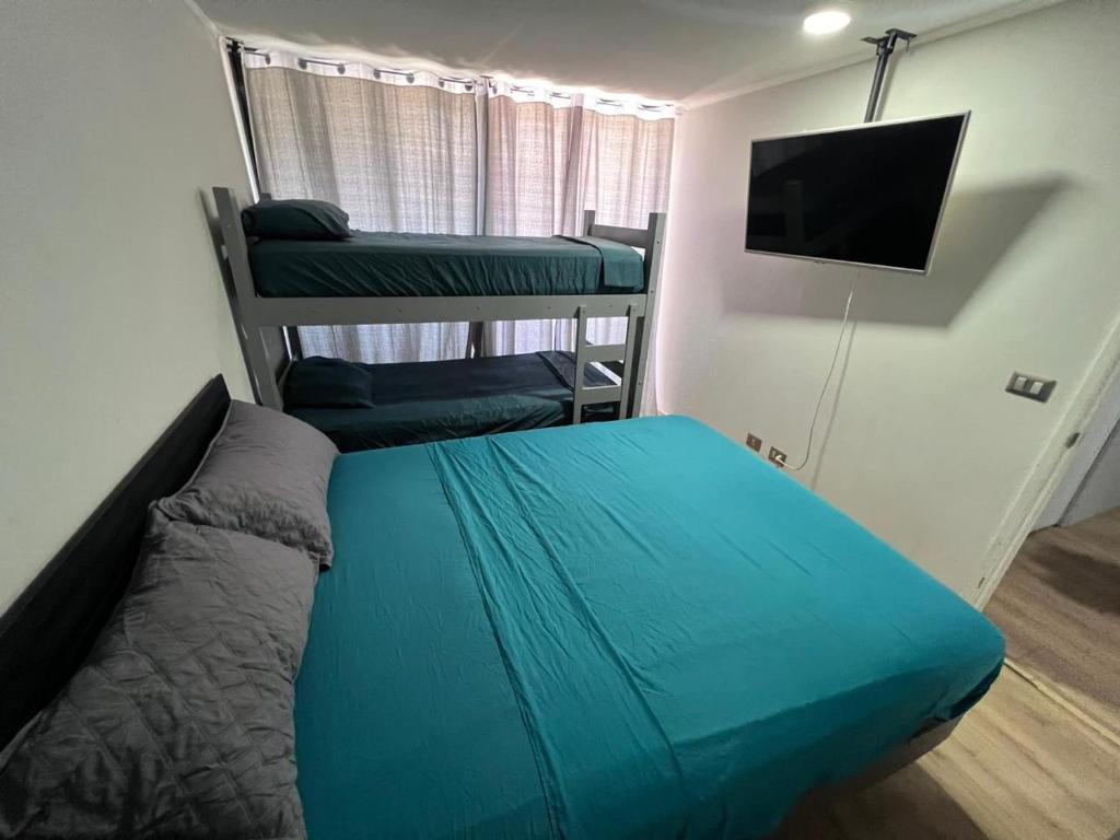Dormitorio pequeño con cama y TV en Habitacion Grande con baño privado en departamento compartido, en Santiago