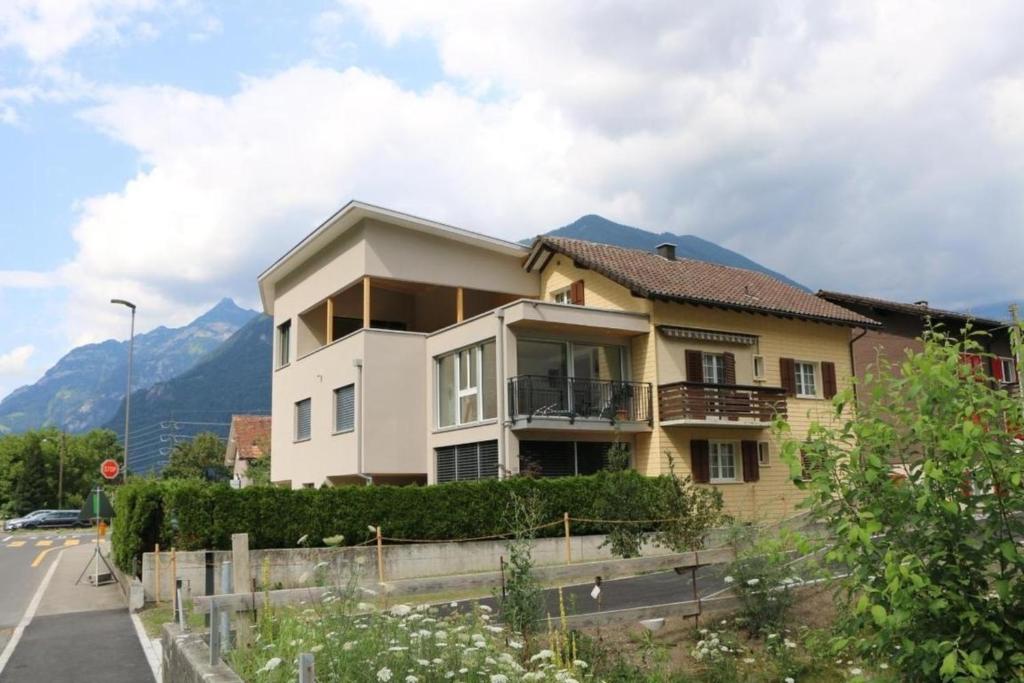 a house on a street with mountains in the background at Ferienwohnung Brüstiblick in Attinghausen
