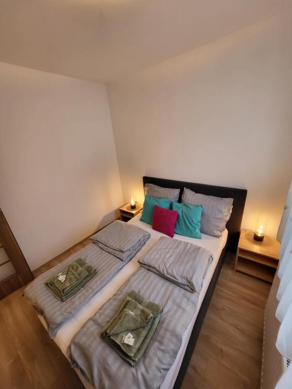 una camera da letto con un grande letto con due cuscini di TriAngol Apartman: fürdő, belváros, egyetem a Győr