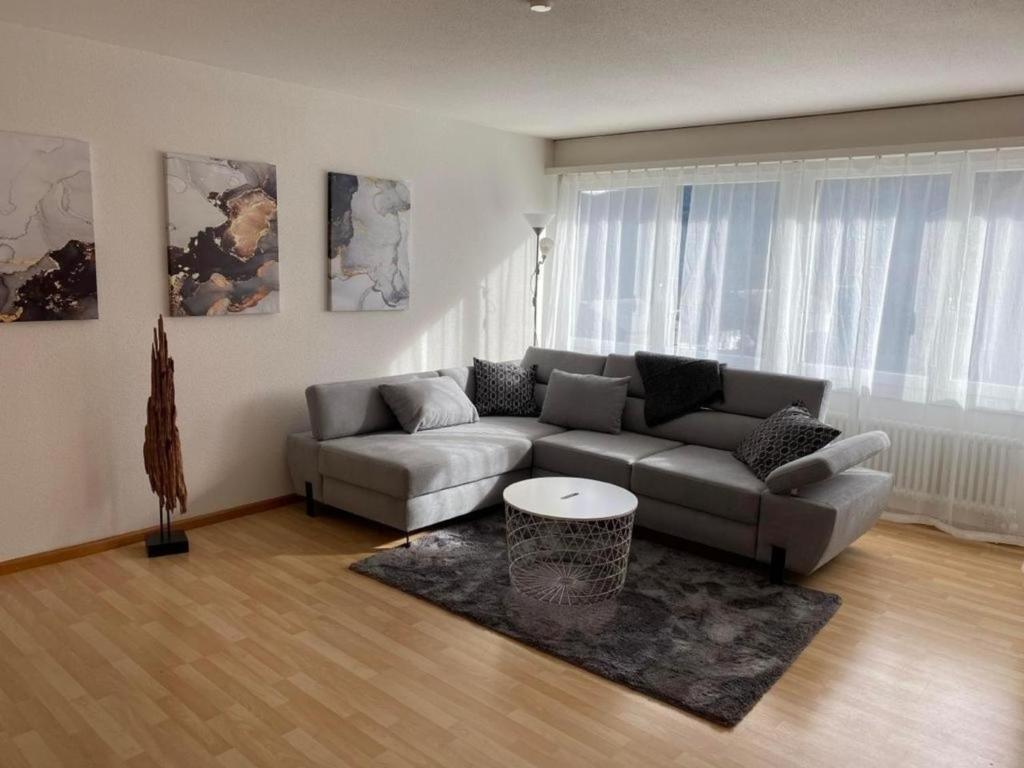 a living room with a couch and a table at Sonnendurchflutete gemütliche Ferienwohnung in Wildhaus