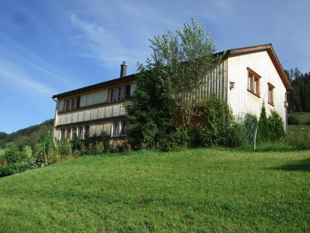 an old building on a hill with a green field at Ballmoos Ferienwohnung in Gais