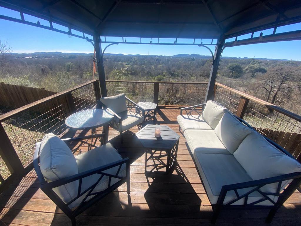 a porch with chairs and a couch and a table at The Overlook~Bandera, TX in Bandera