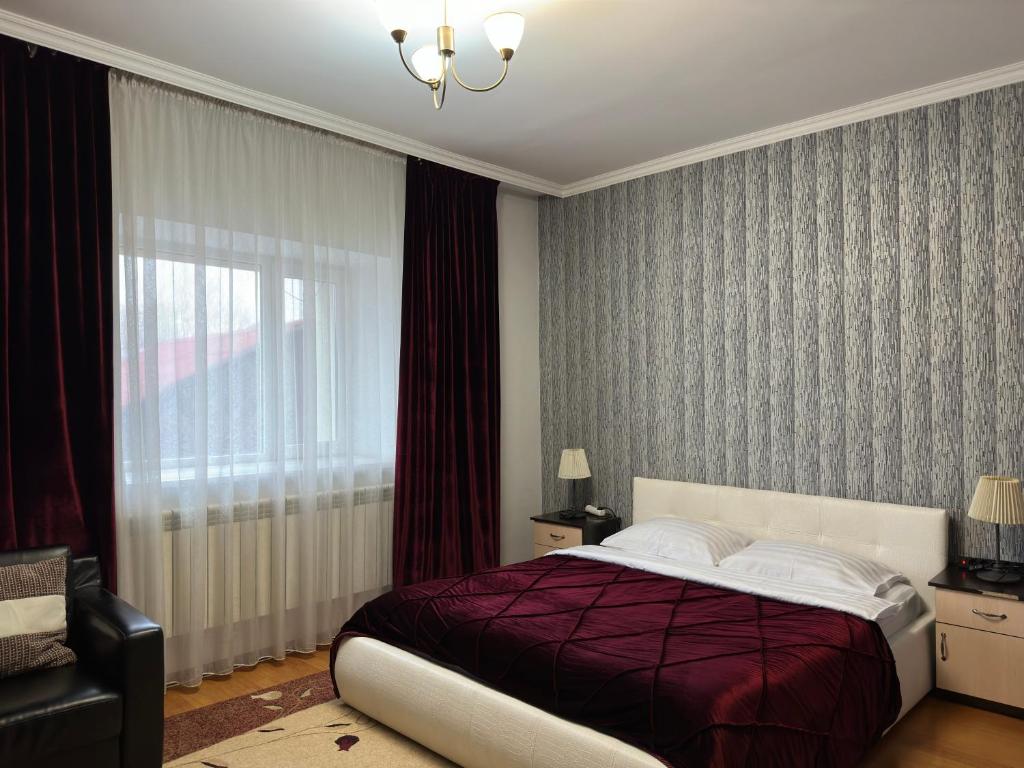 Un dormitorio con una cama grande y una ventana en Mini-Hotel Pulsar, en Astana