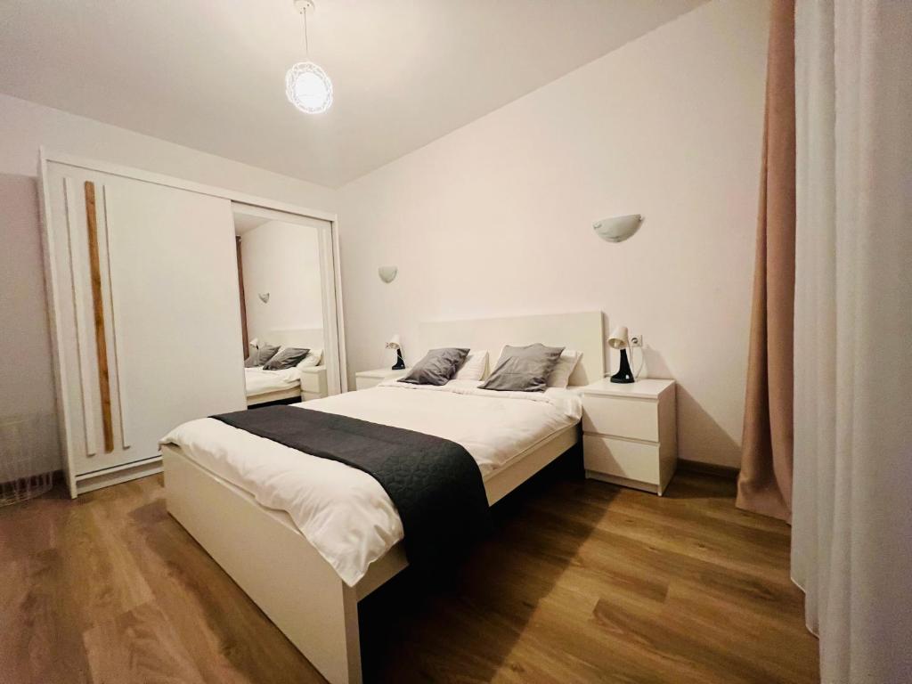 una camera da letto con un grande letto bianco e una finestra di Central Residence a Baia Mare