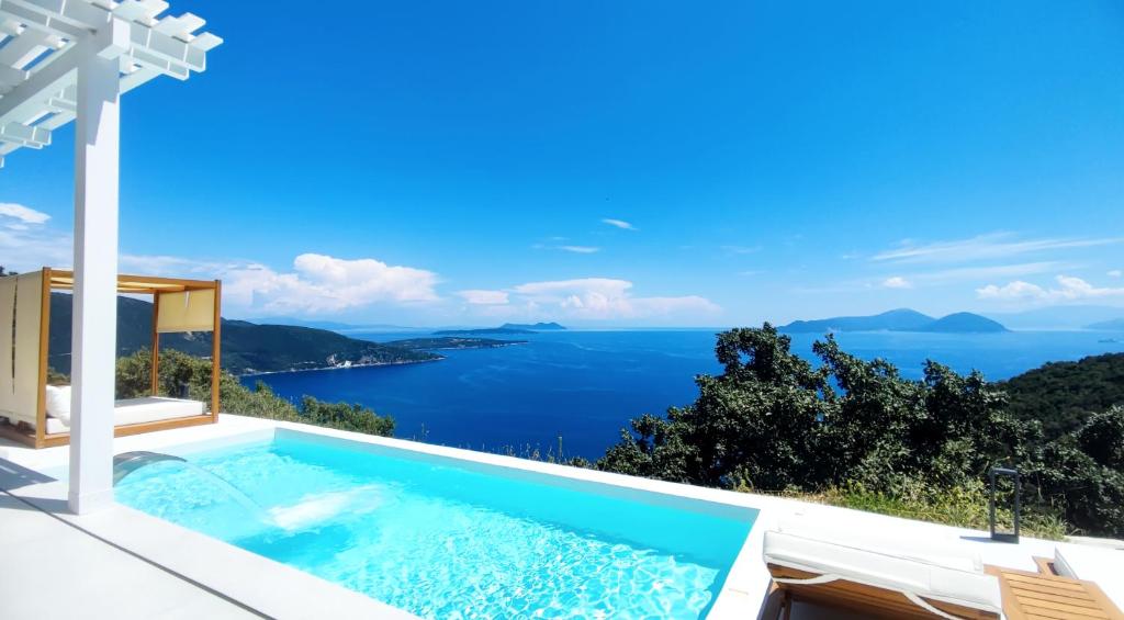 a villa with a swimming pool and a view of the ocean at Urania Luxury Villa Rhea in Póndi