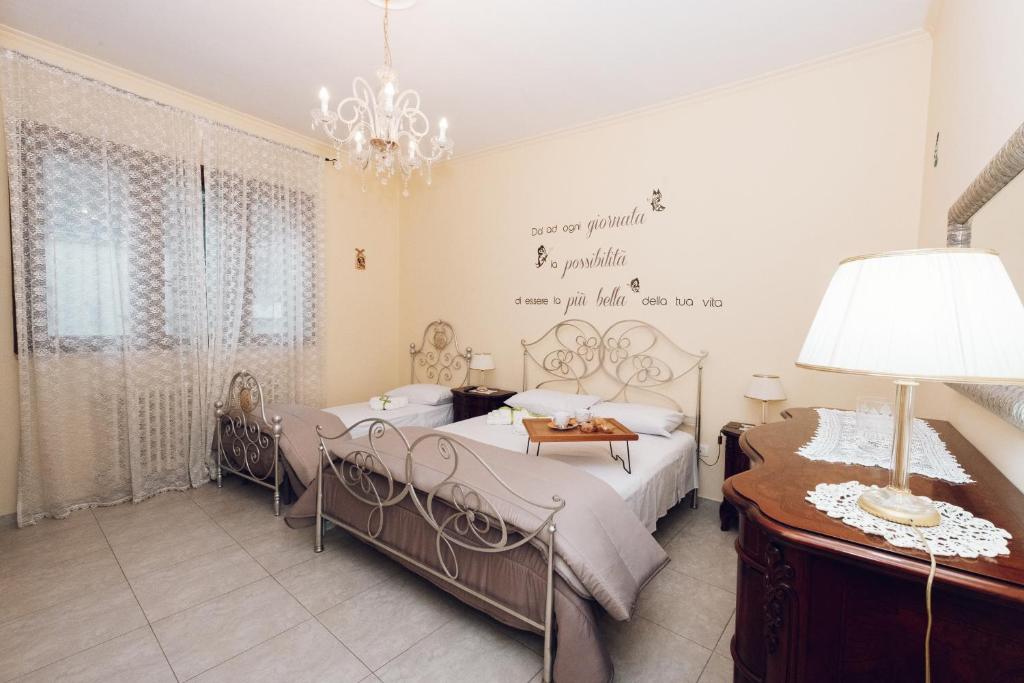 een slaapkamer met 2 bedden en een kroonluchter bij LE QUATTRO STAGIONI in Brindisi