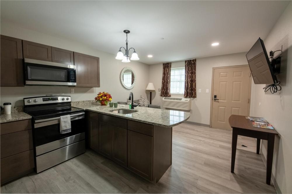 a kitchen with a sink and a stove top oven at Lock Haven Grandview Hotel in Mill Hall